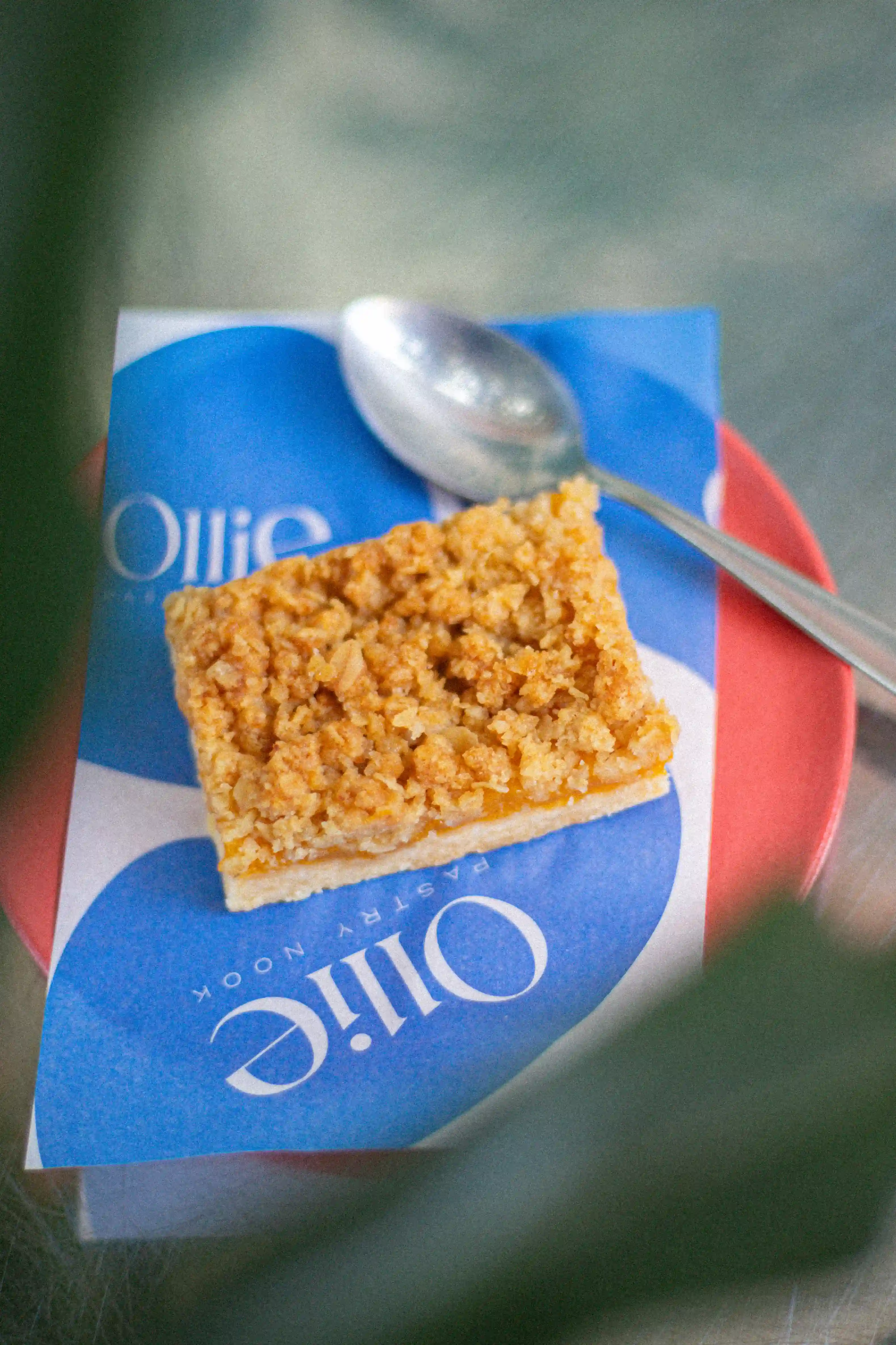 Scone de fresa sobre servilleta azul Ollie con plato rojo